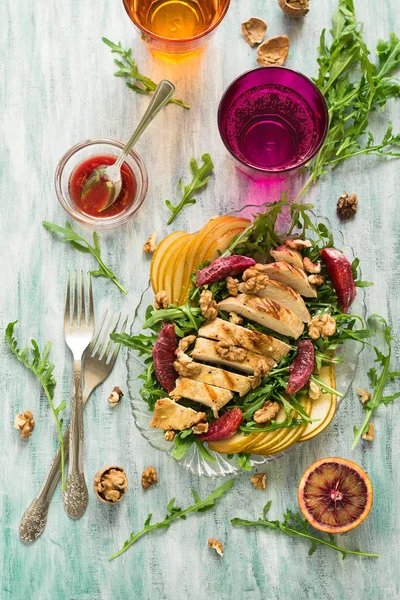 Свежий весенний салат с куриной грудью, рукколой, грушей и апельсинами и грецкими орехами — стоковое фото