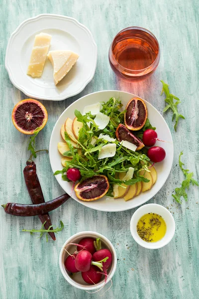 Свежий весенний салат с рукколой, ломтиками груши и апельсина и грецкими орехами — стоковое фото