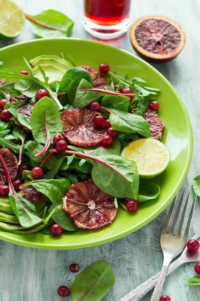 Fresh spring salad with arugula, beet leaves, avocado, red orange slices and cranberry — Stock Photo, Image