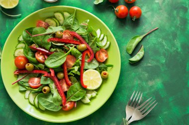 Taze bahar salatası roka, ıspanak, pancar yaprakları, domates, salatalık dilimleri ve tatlı biber