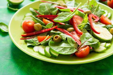 Taze bahar salatası roka, ıspanak, pancar yaprakları, domates, salatalık dilimleri ve tatlı biber