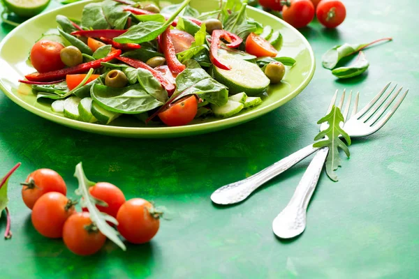 Salada fresca da primavera com arugula, espinafre, folhas de beterraba, tomates, fatias de pepino e pimenta doce — Fotografia de Stock