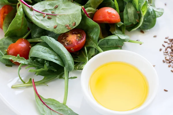 Salada vegetariana de primavera fresca com mistura de alface, tomate cereja, azeite e sementes de linho — Fotografia de Stock