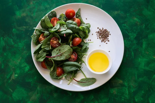 Ensalada vegetariana de primavera fresca con mezcla de lechuga, tomates cherry, aceite de oliva y semillas de lino — Foto de Stock