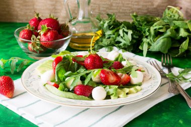 Taze vejetaryen ıspanak, roka, avokado dilimleri, çilek ve mini mozzarella salatası 