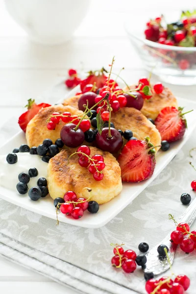 Healthy breakfast: cheese pancakes with sour cream and fresh ripe berries