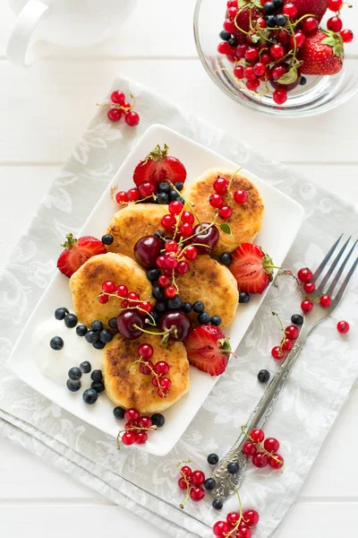 Hälsosam frukost: ost pannkakor med gräddfil och färska mogna bär — Stockfoto