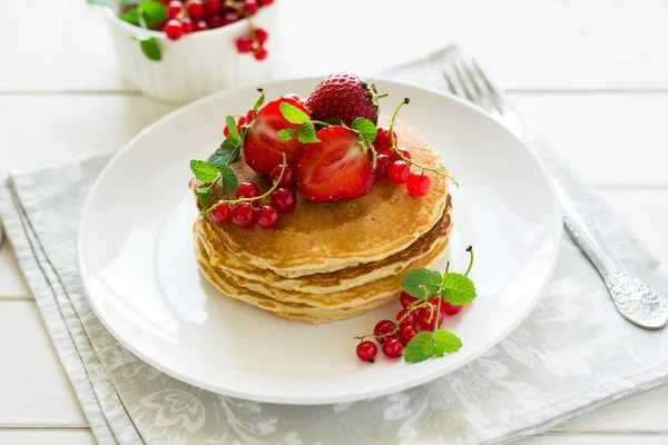 Завтрак: стопка блинов с ягодами, украшенная листьями мяты — стоковое фото