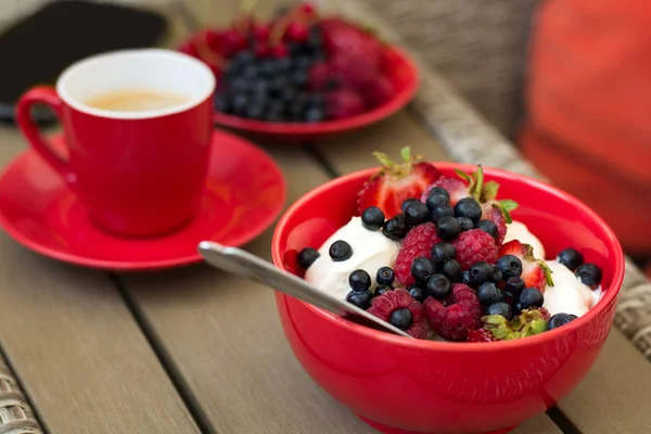 Zdravá snídaně na zahradní nábytek: tvaroh s kysanou smetanou, jahody, maliny a Borůvka, espresso a talíř čerstvých zralých bobulí — Stock fotografie