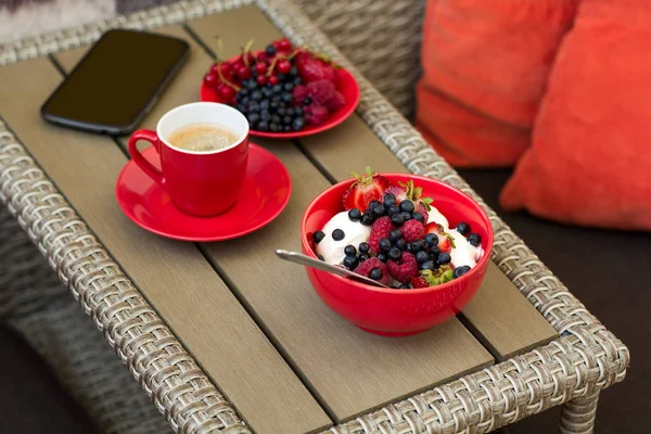 Hälsosam frukost på trädgårdsmöbler: keso med gräddfil, jordgubbar, hallon och blåbär, espresso och tallrik färska mogna bär — Stockfoto