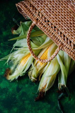 Taze mısır koçanı üzerinde yeşil ahşap masa üzerinde