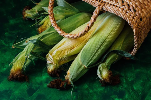 Taze mısır koçanı üzerinde yeşil ahşap masa üzerinde