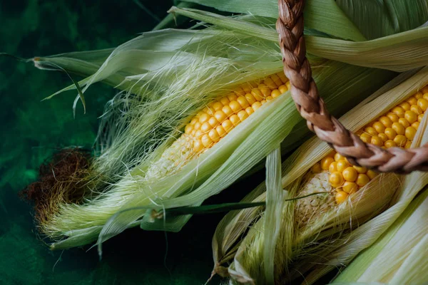 Taze mısır koçanı üzerinde yeşil ahşap masa üzerinde