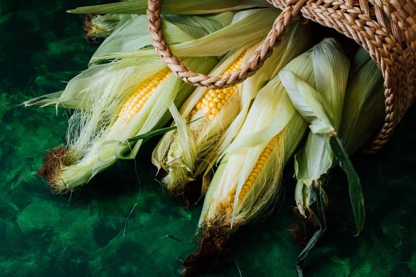 Taze mısır koçanı üzerinde yeşil ahşap masa üzerinde
