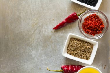 Bezelye, tuz, yağ, pul biber, Kimyon tohumu ve defne yaprağı gri vintage metal mutfak arka plan üzerinde kırmızı sıcak biber biber bakla