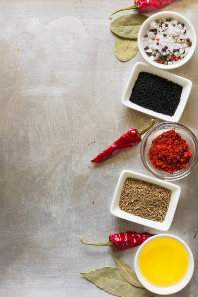 Bezelye, tuz, yağ, pul biber, Kimyon tohumu ve defne yaprağı gri vintage metal mutfak arka plan üzerinde kırmızı sıcak biber biber bakla