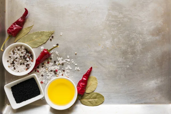 Bezelye, tuz, yağ, siyah kimyon ve defne yaprağı gri vintage metal mutfak arka plan üzerinde kırmızı sıcak biber biber bakla