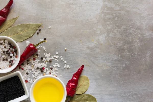 Bezelye, tuz, yağ, siyah kimyon ve defne yaprağı gri vintage metal mutfak arka plan üzerinde kırmızı sıcak biber biber bakla
