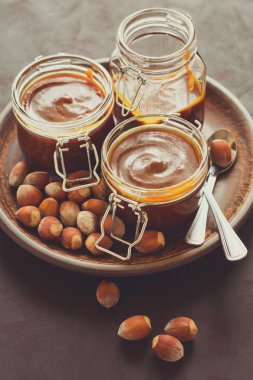 Ev yapımı karamel koyu ahşap masa üzerine fındık ile. Seçici odak. Tonlu görüntü