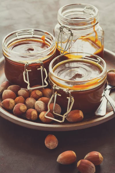 Ev yapımı karamel koyu ahşap masa üzerine fındık ile. Seçici odak. Tonlu görüntü