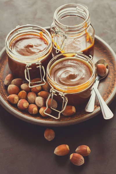 Ev yapımı karamel koyu ahşap masa üzerine fındık ile. Seçici odak. Tonlu görüntü