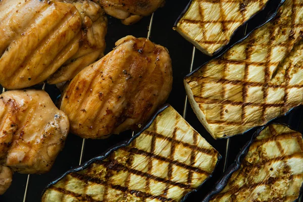 Chicken breasts and eggplants on a grill. Top view — Stock Photo, Image