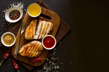 Izgara tavuk göğsü ile baharat ahşap masa üzerinde. Üstten Görünüm. Kopya için alan. Tonlu görüntü