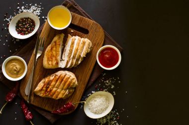 Izgara tavuk göğsü ile baharat ahşap masa üzerinde. Üstten Görünüm. Kopya için alan. Tonlu görüntü