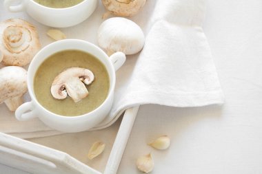 İki geleneksel mantar çorbası beyaz masa örtüsü üzerinde krem ile kase