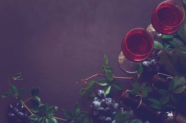 Natürmort kadehlerin, şişe, üzüm ve yaprakları ile