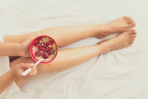 Concepto de alimentación saludable. Manos de mujer sosteniendo tazón con muesli y bayas congeladas — Foto de Stock