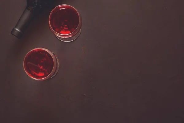 Zwei Weingläser mit Rotwein und liegender Flasche — Stockfoto