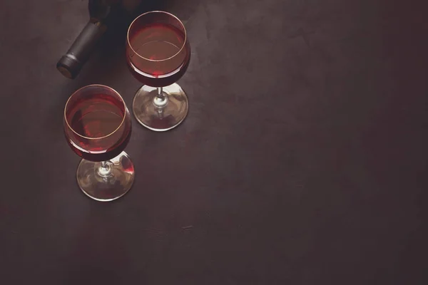 Zwei Weingläser mit Rotwein und liegender Flasche — Stockfoto
