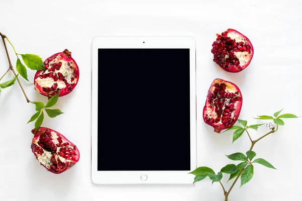 Üstten Görünüm iş tablosu üzerinde. Tablet, yabani üzüm şube ve nar. Düz yatıyordu