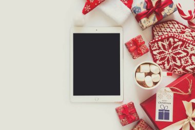 Kraft kağıt, fincan sıcak çikolata ve tablet Noel arka plan el yapımı hediyeler ile sarılmış.