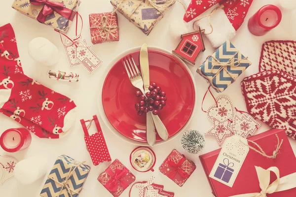 Fond de Noël avec cadeaux faits à la main enveloppés dans du papier artisanal et une plaque rouge . — Photo