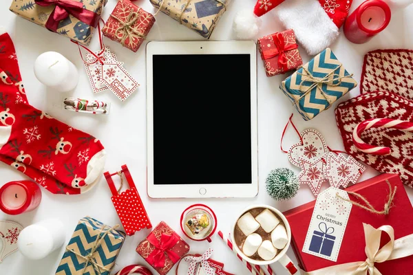 Kraft kağıt, fincan sıcak çikolata ve tablet Noel arka plan el yapımı hediyeler ile sarılmış.