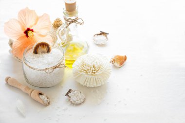 Sağlık ayarı. Deniz tuzu cam, sabun, havlu, zeytin yağı ve beyaz çiçekler arka plan dokulu. Kopya için alan. Düz yatıyordu