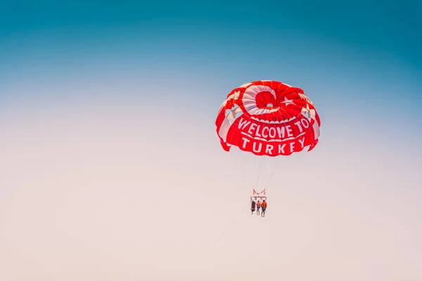 Family flight on a parachute over the sea. Mediterranean sea, Belek, Turkey. Summertime recreation, relax concept.