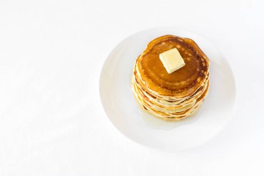 Tereyağı ve beyaz zemin üzerine ballı krep yığını