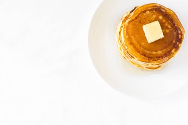 Tereyağı ve beyaz zemin üzerine ballı krep yığını