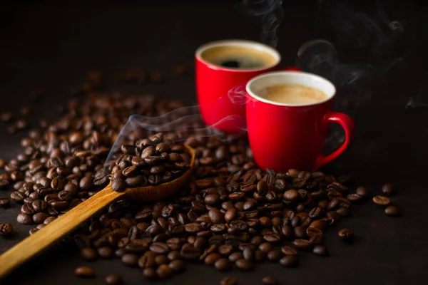 Две Красные Чашки Эспрессо Кофейными Зернами Темном Деревянном Фоне Дым — стоковое фото