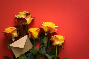 Sarı güller Sevgililer günü için kırmızı kağıt arka plan üzerinde uzanmış düzenlenmiştir. Üstten Görünüm. Kopya için alan