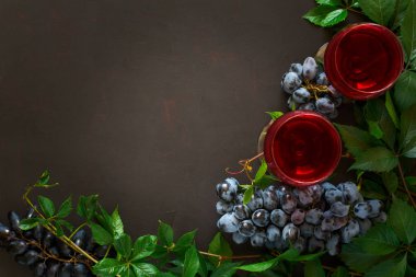 Natürmort kadehlerin, şişe, üzüm ve yaprakları kahverengi ahşap masa