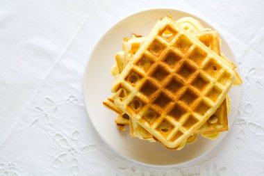 Sağlıklı kahvaltı. Tereyağı, yaban mersini ve fındık üzerinde beyaz masa örtüsü ile Belçika waffle. Seçici odak