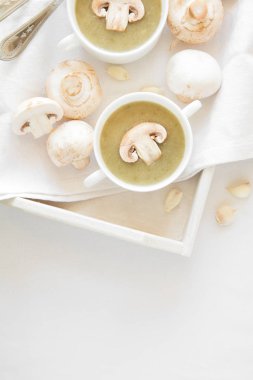 İki geleneksel mantar çorbası beyaz masa örtüsü üzerinde krem ile kase