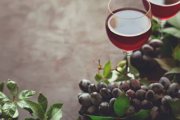 仍然生活与酒杯 葡萄和叶子在褐色木桌 — 图库照片