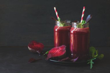 Taze pancar güler yüzlü, pancar, roka ve marul yaprakları koyu ahşap arka plan üzerinde