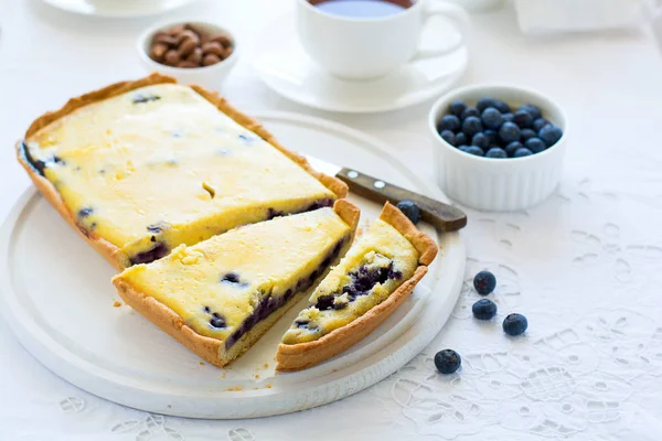 Çay saati. Ev yapımı yaban mersinli cheesecake, bardak çay, fındık ve berry beyaz masa örtüsü