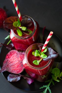 Taze pancar güler yüzlü, pancar, roka ve marul yaprakları koyu ahşap arka plan üzerinde